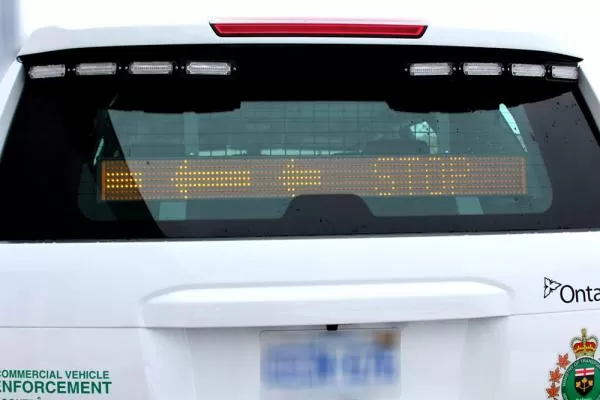 D&R RAT-A-40U amber LED message sign in the rear window of an enforcement SUV showing an arrow and STOP