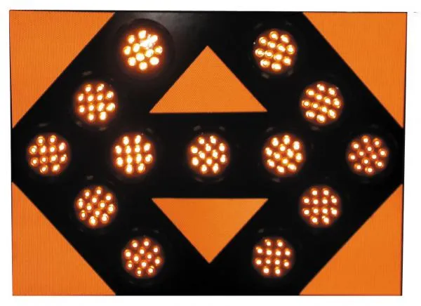 Close-up of the lit face, thirteen amber LED modules glowing against the orange reflective panel