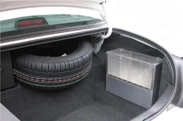 D&R SB04 aluminum storage box with plexi-glass latching cover mounted in a car trunk beside the spare tire