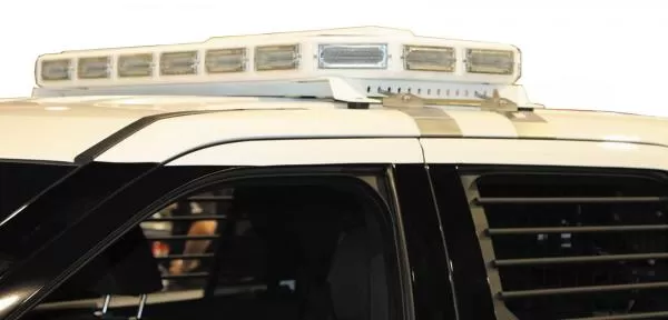 Board retracted flush into the low-profile roof unit on a white SUV, all LED modules unlit
