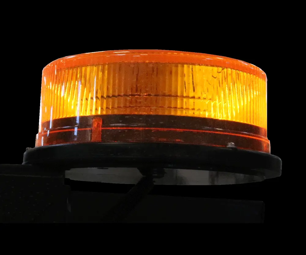 Amber-lens LED beacon seen from the side, shallow fluted dome on its moulded mounting base