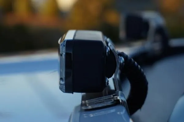 Back of a roof mounted light at dusk showing the coiled supply cable and the adjustable metal bracket