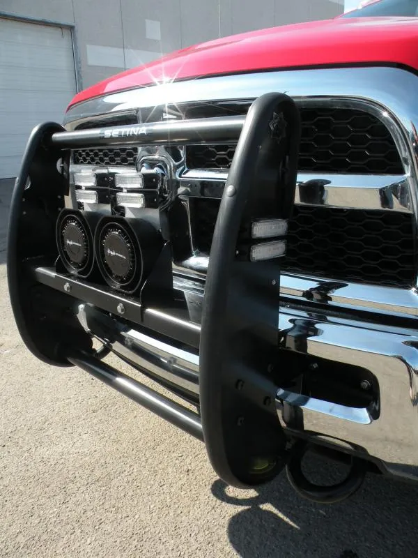 Warning lights and two D&R speakers mounted behind the black push bumper of a red rescue truck