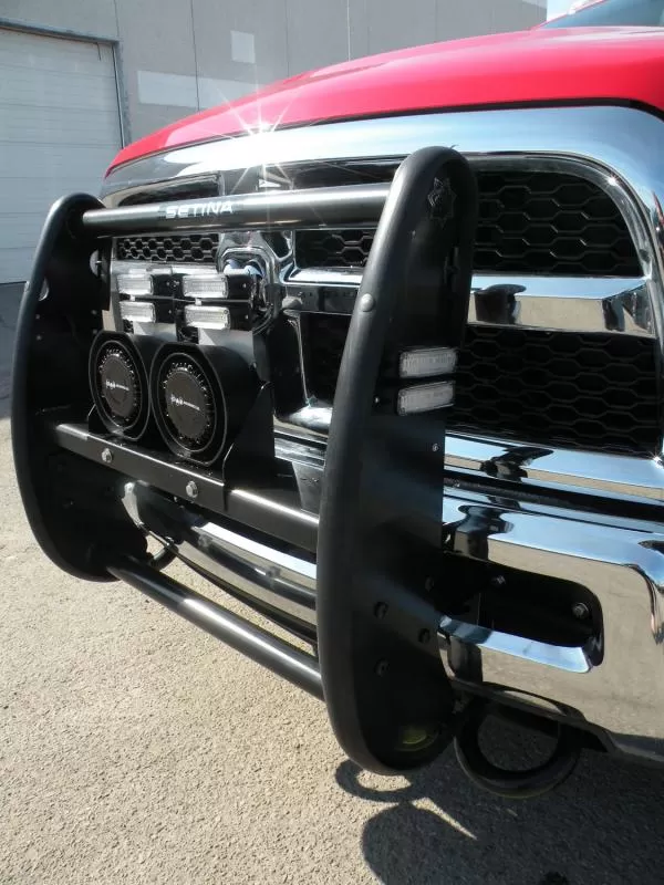 Warning lights and two D&R speakers mounted behind the black push bumper of a red rescue truck
