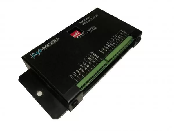 Angled view of the visor light flasher showing its mounting flange and two green terminal strips