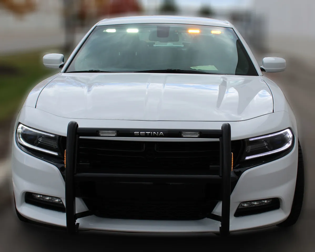 White Dodge Charger with the visor bar lit at the top of the windshield and amber lights in the push bumper