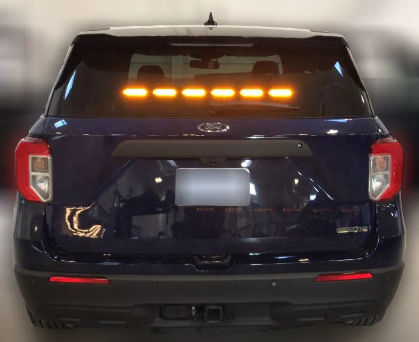 Dark Ford Explorer with all six rear-window modules lit steady amber in a straight line