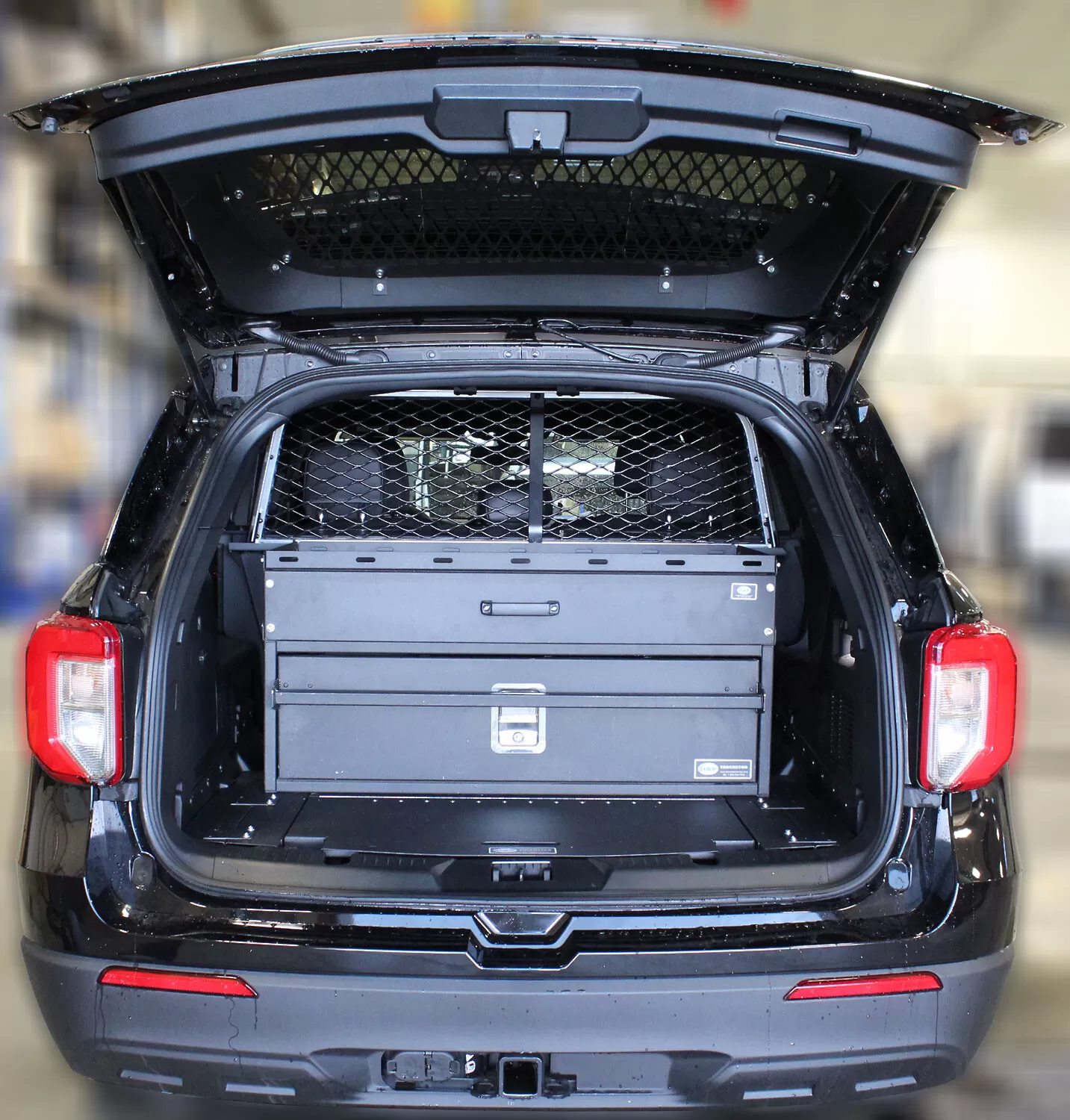 Liftgate open on a black Explorer showing the hatch glass screen and the drawer unit in the cargo bay