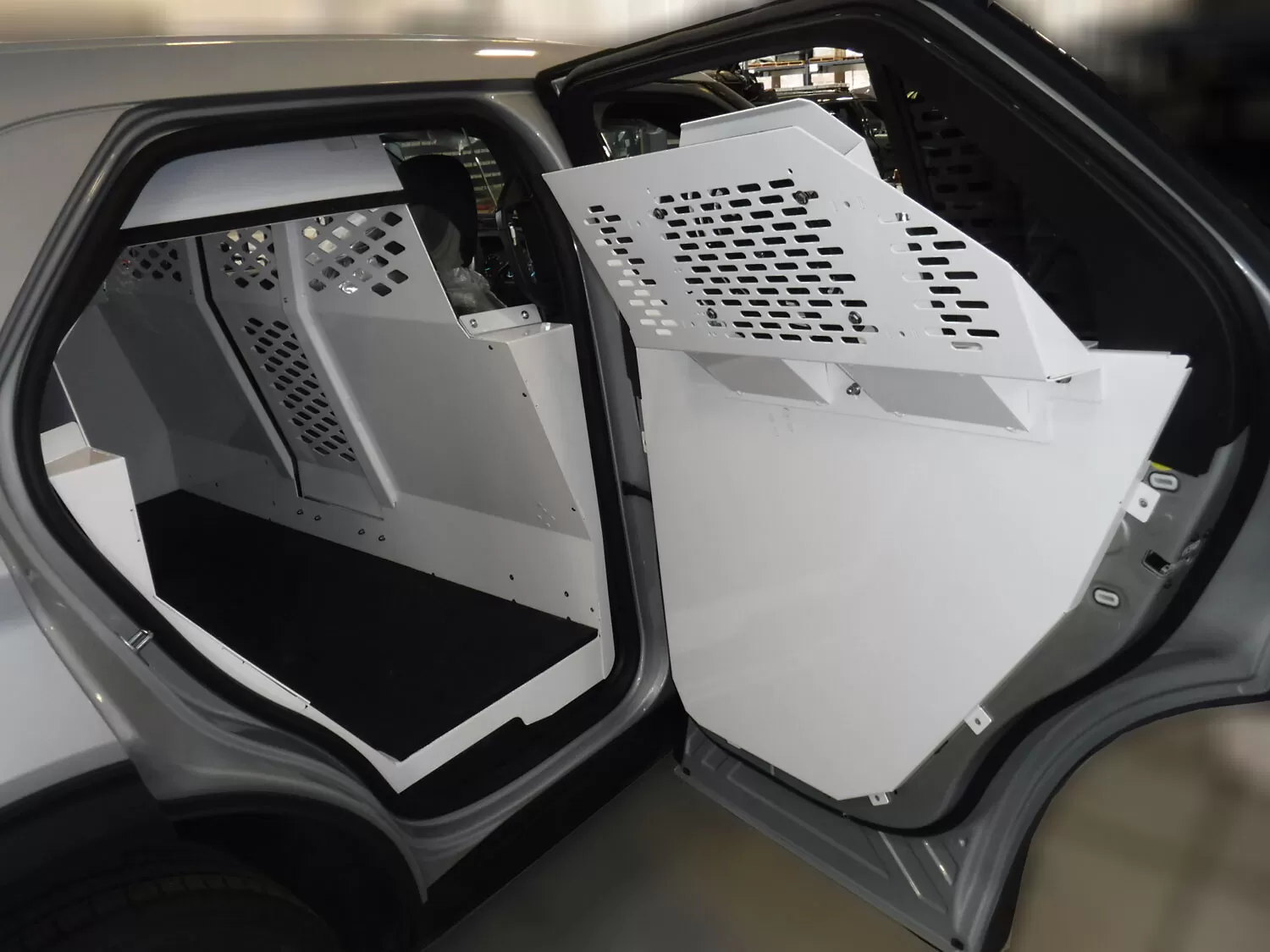 Both rear doors open on the white partition panels above a black rubber floor mat