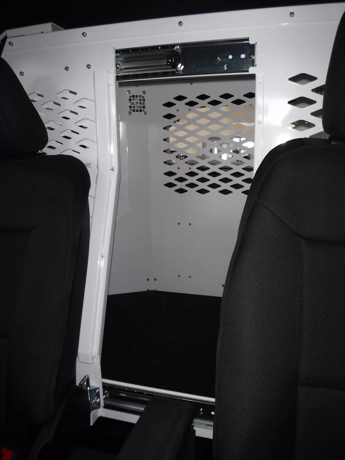 Front barrier seen from the front seats, diamond-mesh window and overhead slide track for the dog door
