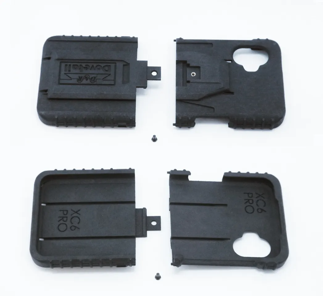 All four molded parts and two mounting screws laid out flat, dock face above, phone cavity below