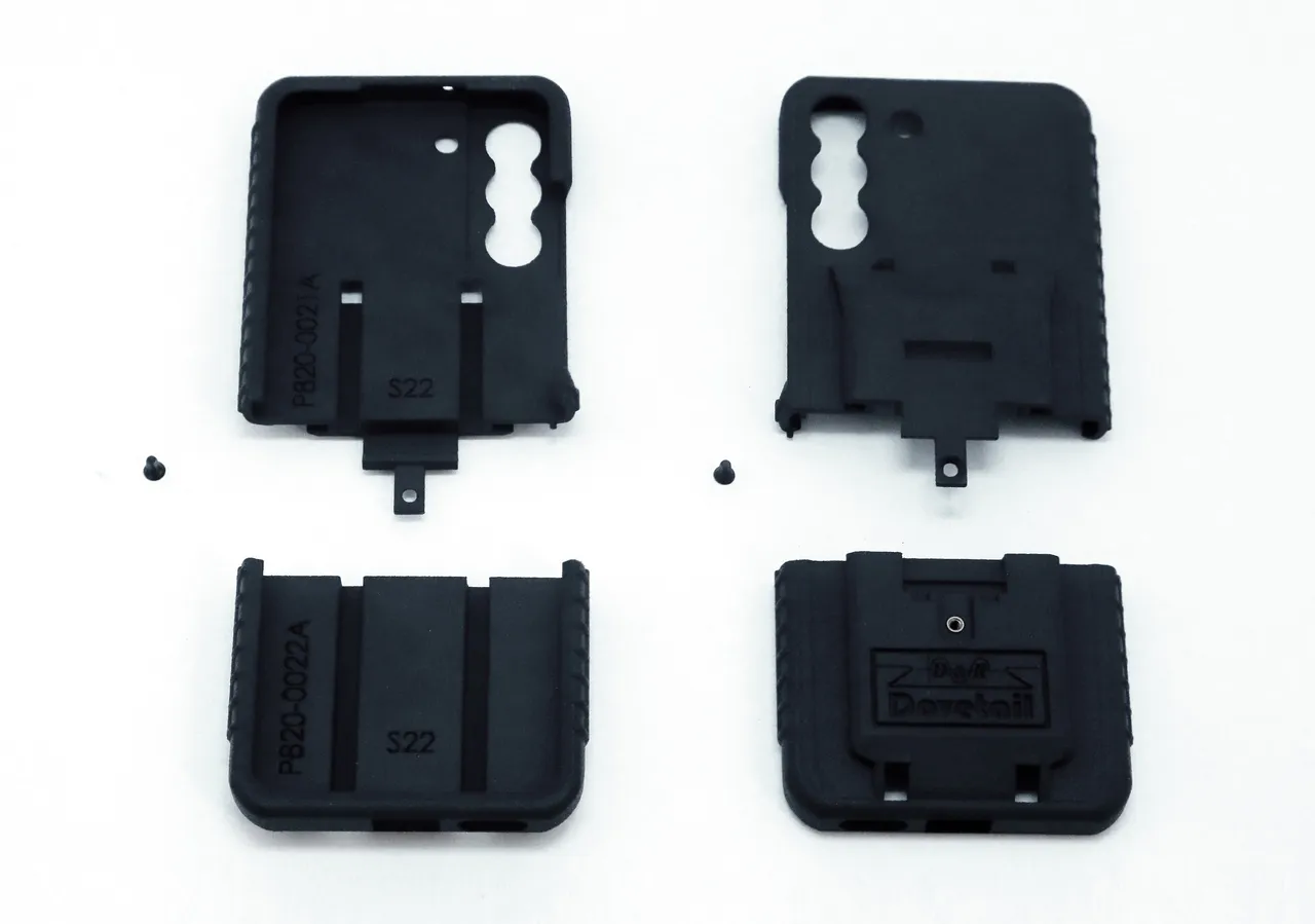 All four moulded parts and the two assembly screws laid out on white before assembly