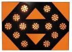 Close-up of the lit face, thirteen amber LED modules glowing against the orange reflective panel