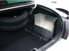 Angled view of the trunk-mounted box showing the clear latching cover and its floor mounting brace