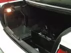 Door swung open in the trunk, exposing the mounting space behind it and the spare tire well