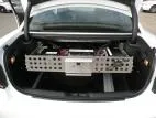 Rear view of the slide-out tray carrying a wired D&R power module and fuse block across the trunk