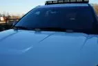 Two flush mount lights fitted at the back of a white SUV hood with the roof lightbar behind the windshield