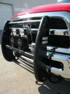 Warning lights and two D&R speakers mounted behind the black push bumper of a red rescue truck