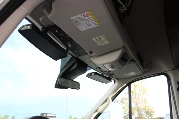 Looking up at a Transit windshield header where the black bar bracket sits beside the sun visor