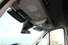Looking up at a Transit windshield header where the black bar bracket sits beside the sun visor