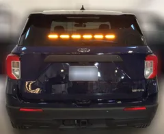 Dark Ford Explorer with all six rear-window modules lit steady amber in a straight line