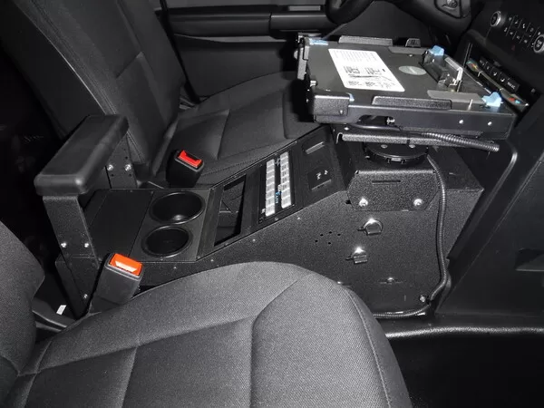 Console installed with a laptop dock on its swing arm, breaker panel and two cup holders below