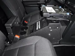 Console installed with a laptop dock on its swing arm, breaker panel and two cup holders below