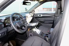 Console fitted in a white Ford SUV, empty dock plate ahead of the cup holders and 12V outlet