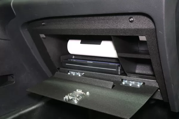 Close view of the open glove box with the paper roll above the printer and the door latch strikes